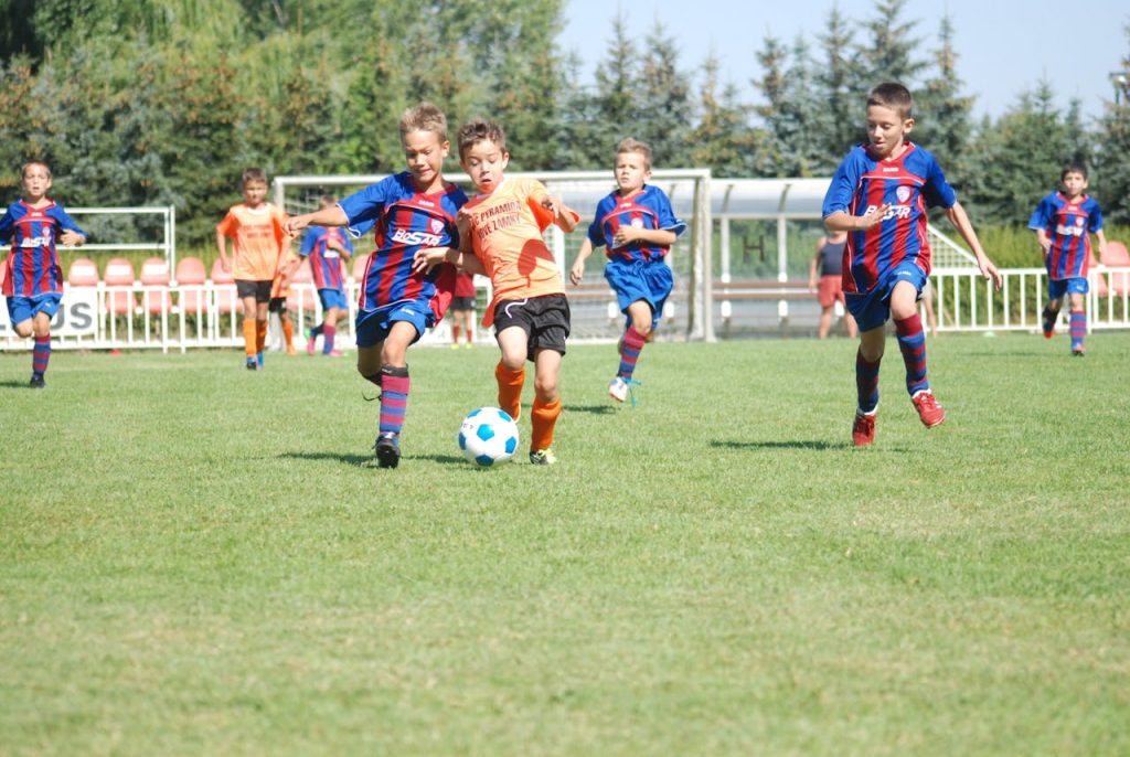 Kids passionately playing soccer in a vibrant outdoor setting, embodying teamwork and energy.