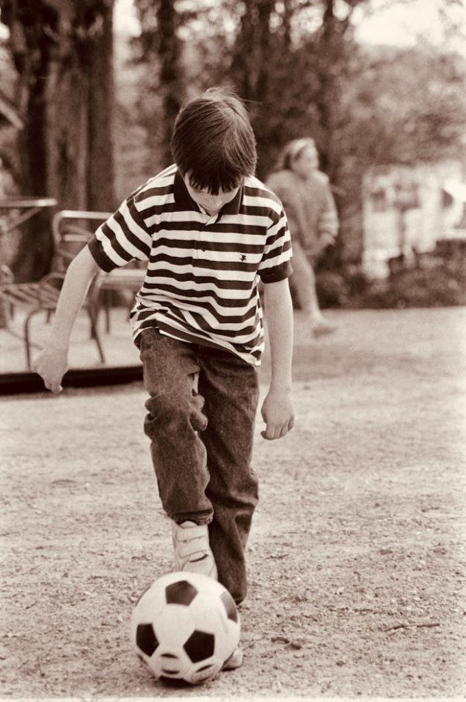 A young boy practicing soccer skills outdoors in Mons, Belgium.